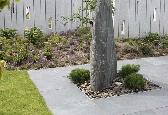 Skifferskulptur i haven og granitmur designet af havearkitekt Tor Haddeland