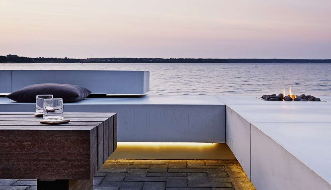 Lyst loungemoebel med udsigt over havet designet af havearkitekt Tor Haddeland