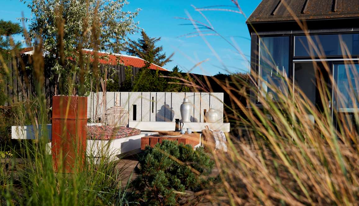 Terrasse med lounge og granitmur tegnet af havearkitekt Tor Haddeland